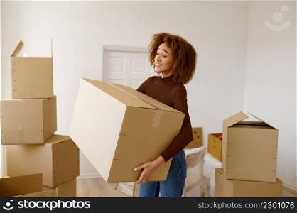 Tired young woman standing among cardboard boxes. Problem with relocation, hard moving day. Tired young woman standing among cardboard boxes