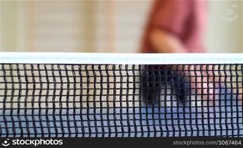 Tischtennis - Spiele schlagt einen Schmetterball, der ins Netz geht, Fokus liegt auf dem Netz