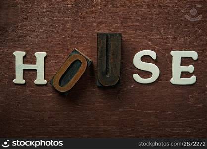 Tjhe word house written on wooden background