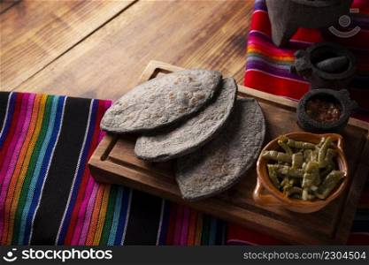 Tlacoyos and Nopales. Mexican pre hispanic dish made of blue corn flour patty filled with refried beans. Popular street food in Mexico. Copy space