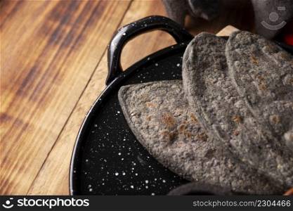 Tlacoyos. Mexican pre hispanic dish made of blue corn flour patty filled with refried beans. Popular street food in Mexico.