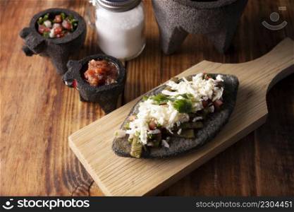 Tlacoyos with Nopales and salsa. Mexican pre hispanic dish made of blue corn flour patty filled with refried beans. Popular street food in Mexico.