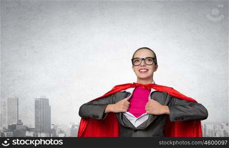To be super woman takes strength. Businesswoman wearing red cape and opening her shirt like superhero