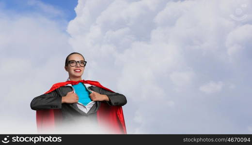 To be super woman takes strength. Businesswoman wearing red cape and opening her shirt like superhero