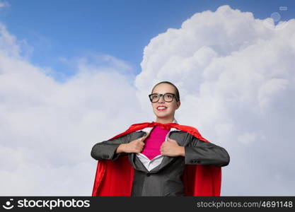 To be super woman takes strength. Businesswoman wearing red cape and opening her shirt like superhero