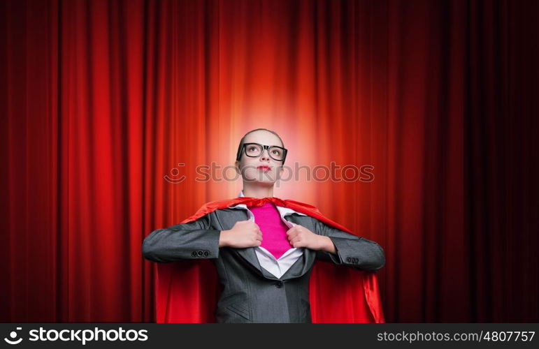 To be super woman takes strength. Businesswoman wearing red cape and opening her shirt like superhero