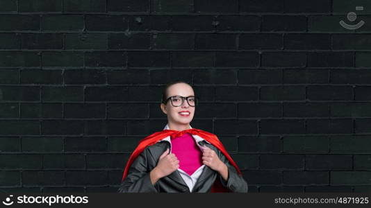 To be super woman takes strength. Businesswoman wearing red cape and opening her shirt like superhero