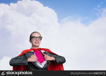 To be super woman takes strength. Businesswoman wearing red cape and opening her shirt like superhero