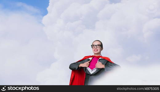 To be super woman takes strength. Businesswoman wearing red cape and opening her shirt like superhero