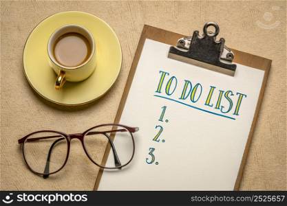 to do list handwriting in a clipboard, flat lay with a cup of coffee and glasses, business, productivity, planning and personal development concept