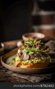 Toast avocado, mushrooms and microgreens whole grain sandwich. Vegetarian food. Vegan menu. Delicious breakfast or snack, Clean eating, dieting, vegan food concept.. Toast avocado and mushrooms