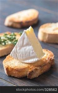 Toast with Camembert cheese on the wooden board