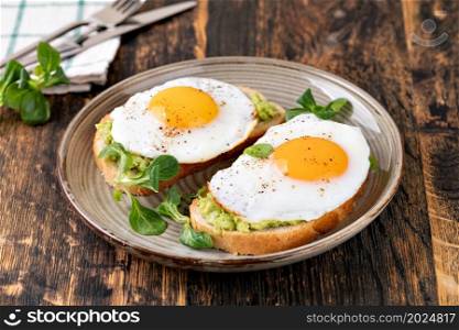 toast with fried egg on a wooden table. toast with fried egg