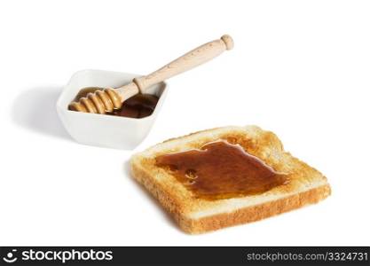 toast with honey an a honey jar with a honey dipper. toast with honey an a honey jar with a honey dipper on white background from slightly top