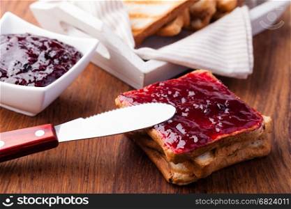 Toast with jam. Toast with jam on a wooden table