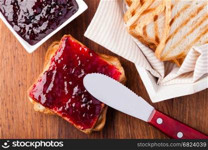 Toast with jam. Toast with jam on a wooden table