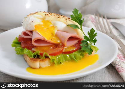 Toast with slices of ham and tomatoes, Benedict egg with Dutch sauce.