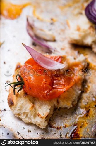 Toasted bread with crushed baked tomato on metal baking tray, selective focus