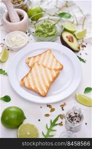 Toasts preparation - grilled toast bread and mashed avocado.. Toasts preparation - grilled toast bread and mashed avocado