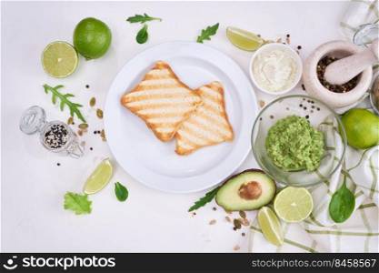 Toasts preparation - grilled toast bread and mashed avocado.. Toasts preparation - grilled toast bread and mashed avocado
