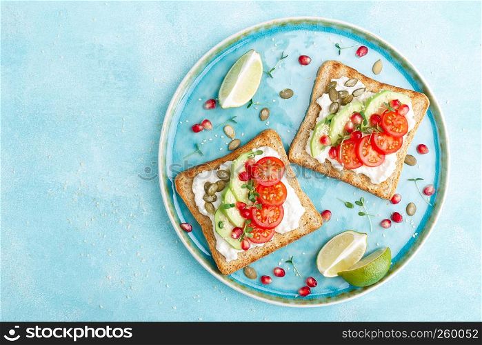 Toasts with feta cheese, tomatoes, avocado, pomegranate, pumpkin seeds and flaxseed sprouts. Diet breakfast. Delicious and healthy food. Flat lay. Top view
