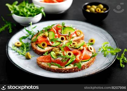 Toasts with salted salmon, arugula, green olives and cucumber