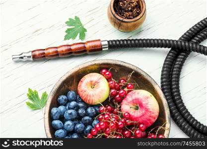 Tobacco hookah.Shisha mouthpiece and parts for the smoking hookah.Kalian with berries and apple. Arabia shisha with berries and apple