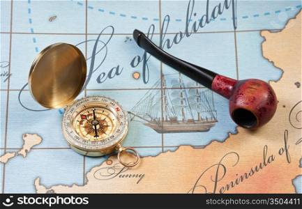 tobacco pipe and a compass on the map
