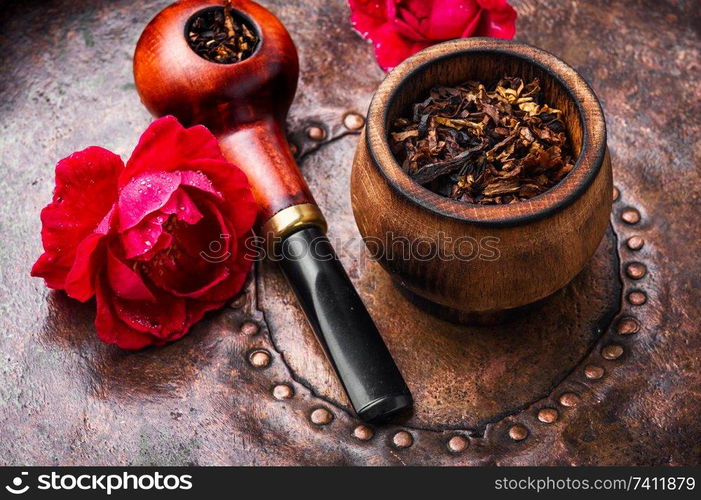 Tobacco pipe and smoking tobacco with rose flavor.Refined taste of tobacco. Smoking rose-flavored tobacco