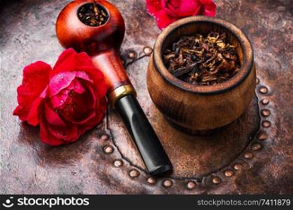 Tobacco pipe and smoking tobacco with rose flavor.Refined taste of tobacco. Smoking rose-flavored tobacco