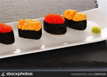 Tobiko and spice sushi on a slate plate