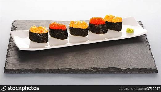 Tobiko and spice sushi on a slate plate