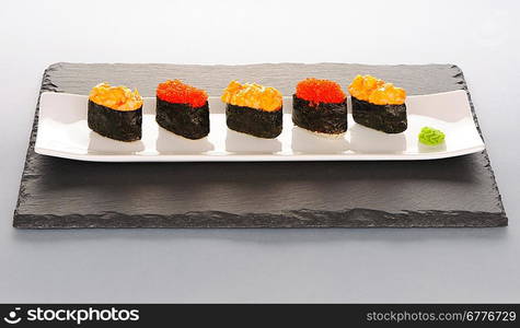 Tobiko and spice sushi on a slate plate