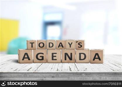 Today&rsquo;s agenda sign on a wooden desk in a bright classroom with colors