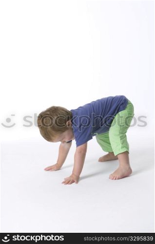 Toddler Boy Is Standing On Hands And Feet Trying To Get Up