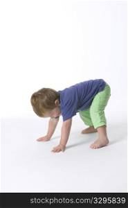 Toddler Boy Is Standing On Hands And Feet Trying To Get Up