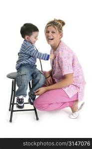 Toddler boy listening to nurse&acute;s heart with stethoscope. Shot in studio.