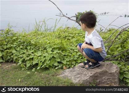 Toddler boy looking out at lake.