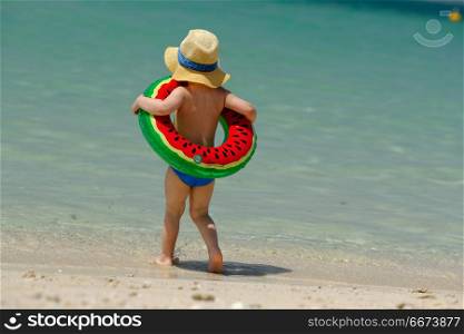 Toddler boy with swim ring on beach . Two year old toddler boy with inflatable swim ring on beach