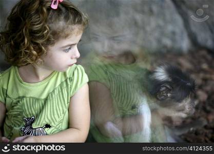 Toddler girl at zoo looking at the monkey and feeling the connection