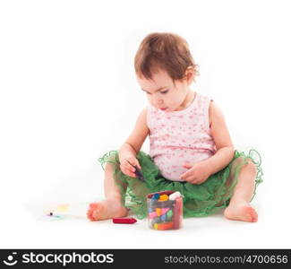 Toddler girl draws with wax crayons on the paper