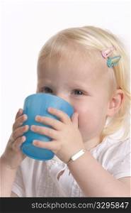 Toddler Girl Is Drinking From A Blue Plastic Cup