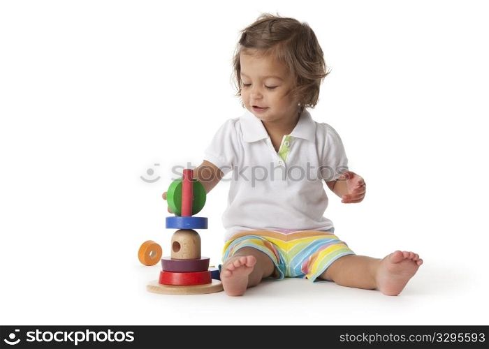 Toddler girl playing with colored bricks on white background