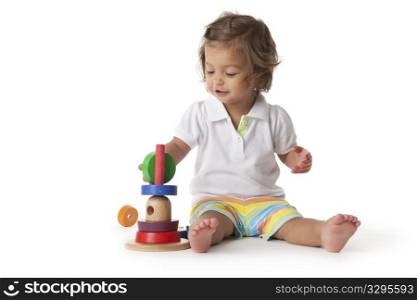 Toddler girl playing with colored bricks on white background