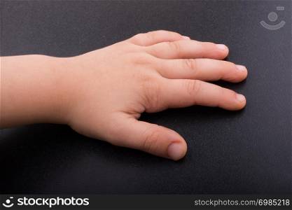 Toddler hand with dark color background