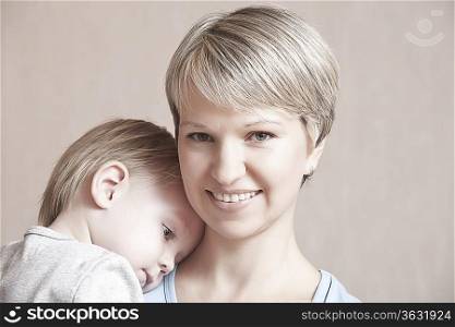 Toddler is comforted leaning head on mother&acute;s shoulder