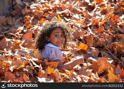 Toddler kid girl playing with autumn leaves latin ethnicity