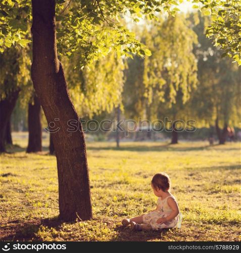toddler sitting under the tree