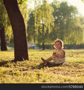 toddler sitting under the tree