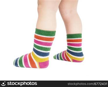 Toddler standing in striped socks and bare legs isolated on white